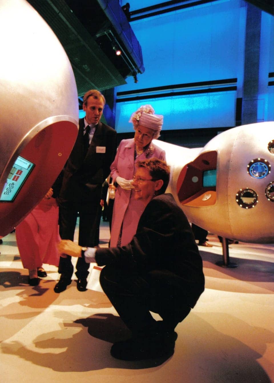 The Queen and two men using interactive computer embedded into metal structure