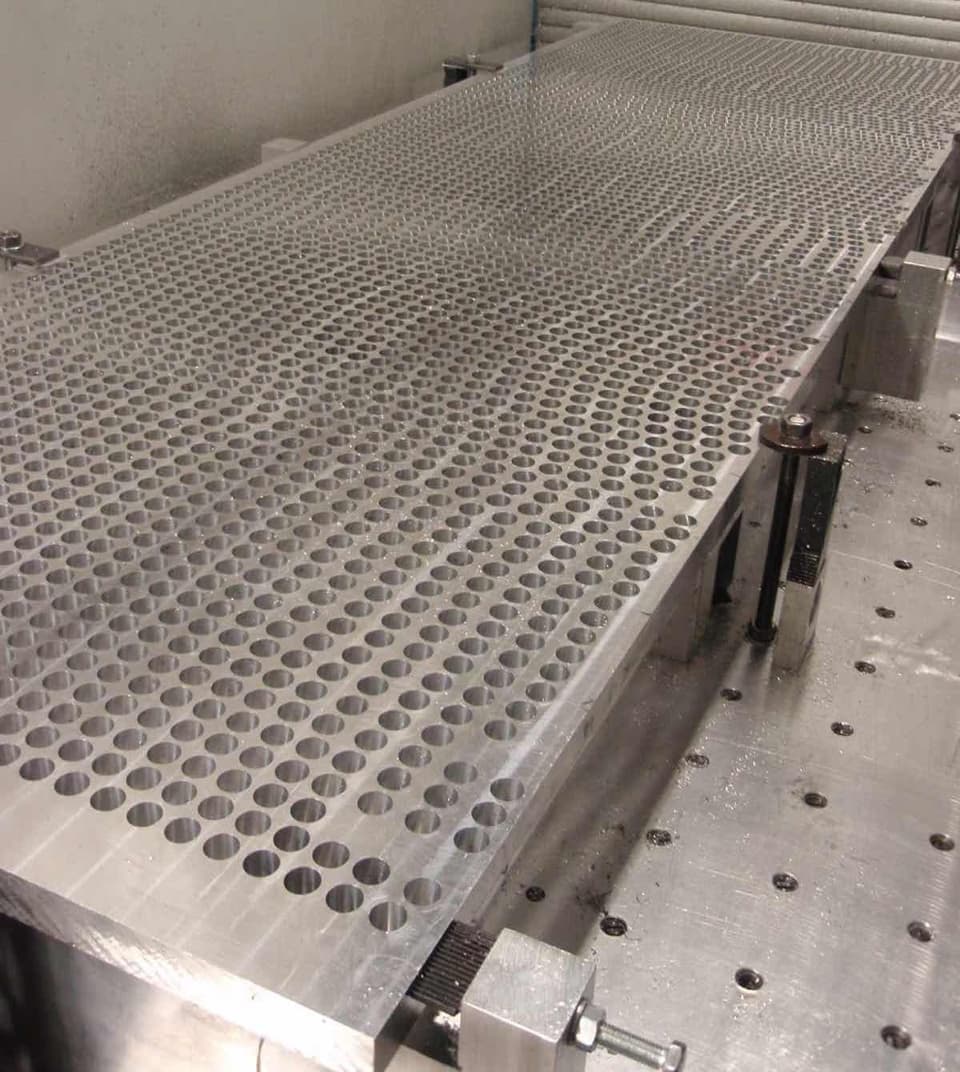 Aluminium plate on CNC machine with lots of machined holes